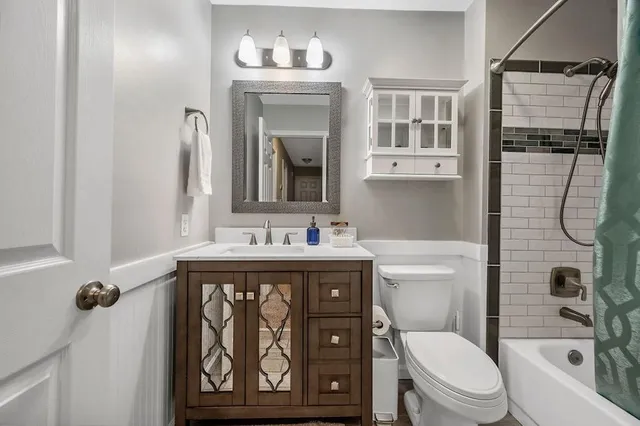 a bathroom with a granite countertop toilet sink and mirror
