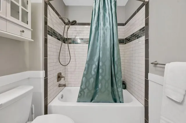 a bathroom with a shower a toilet and a shower