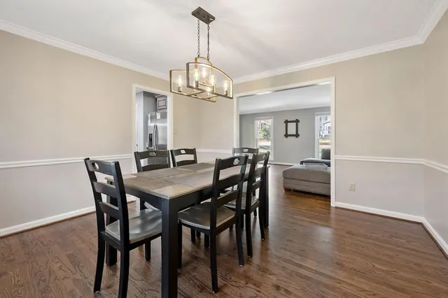 a view of a dining room with furniture a chandelier and wooden floor