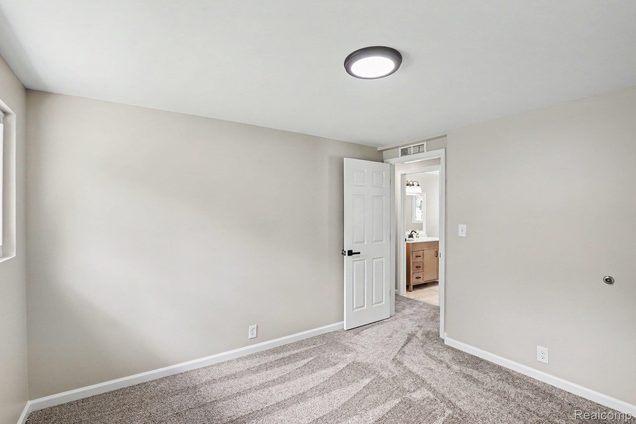 74600 Nordman Court Romeo, MI 48065 - Photo 17 of 32 Interior room featuring light-colored walls and patterned carpet flooring