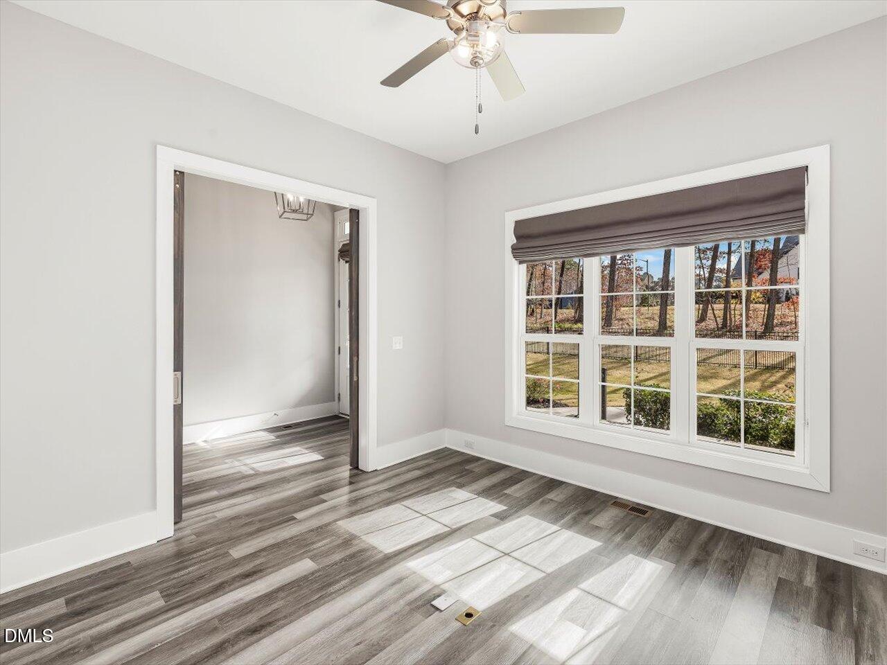 5212 Purnell Road Wake Forest, NC 27587 - Photo 22 of 36 an empty room with wooden floor and windows