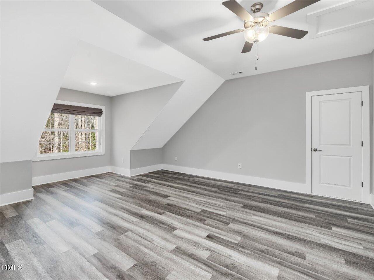 5212 Purnell Road Wake Forest, NC 27587 - Photo 25 of 36 an empty room with wooden floor chandelier fan and windows
