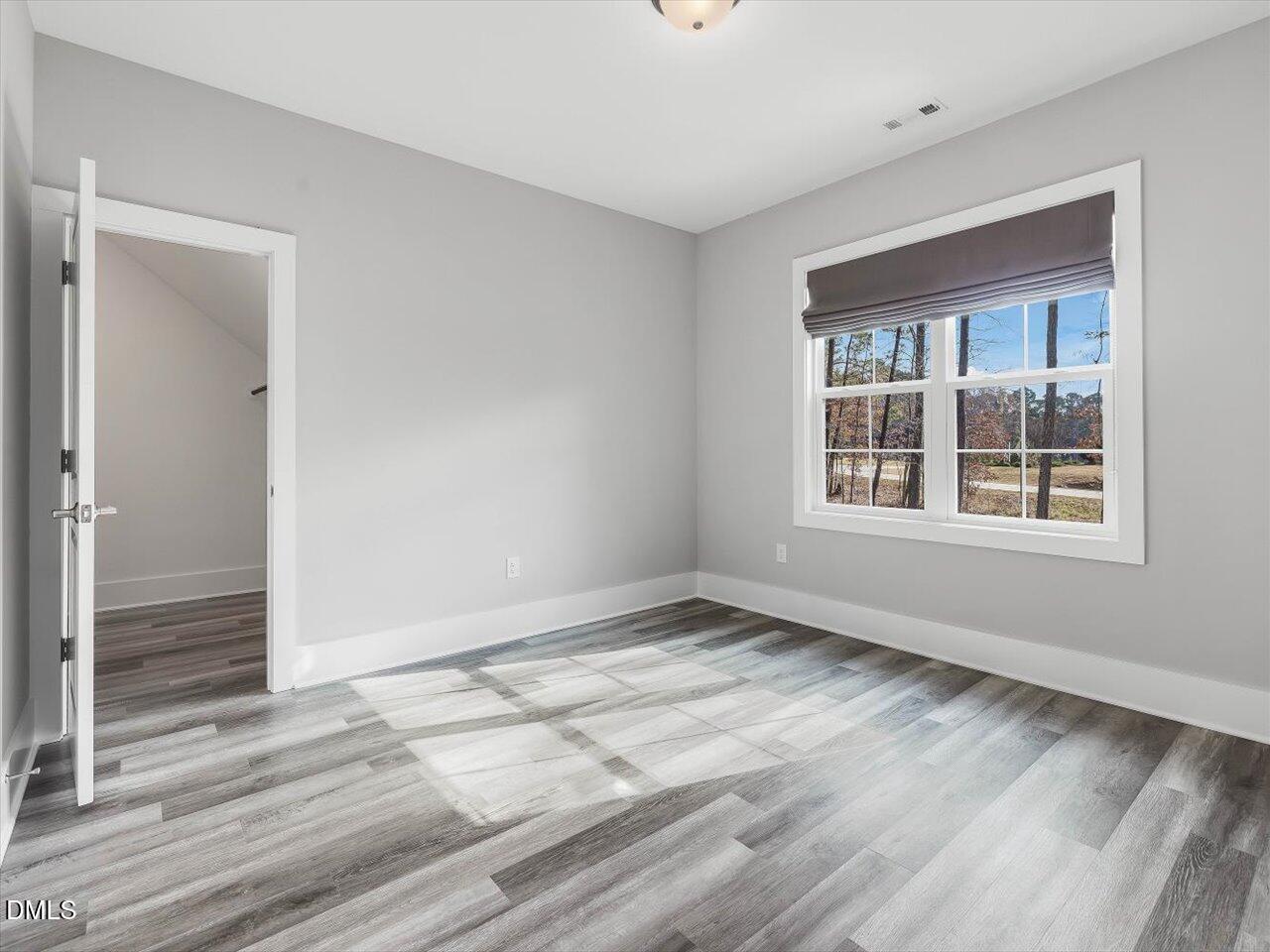5212 Purnell Road Wake Forest, NC 27587 - Photo 26 of 36 an empty room with wooden floor and windows