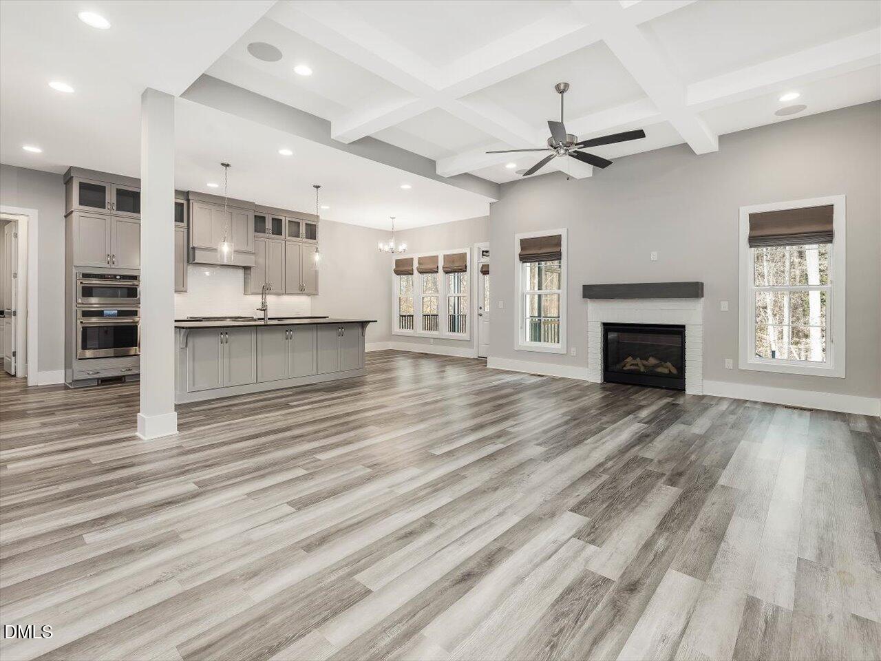 5212 Purnell Road Wake Forest, NC 27587 - Photo 35 of 36 an empty room with wooden floor a ceiling fan and kitchen view