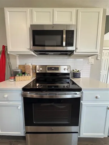 a kitchen with stainless steel appliances granite countertop a stove microwave and oven