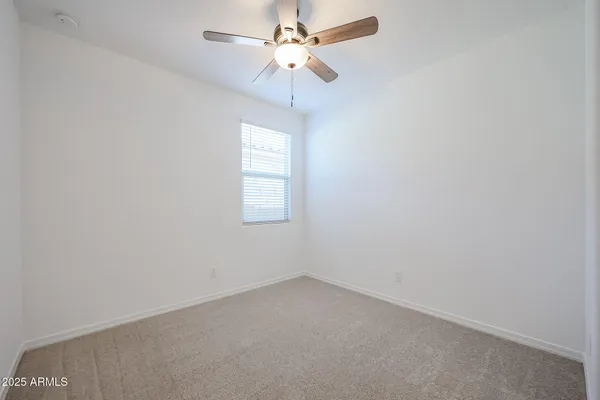 an empty room with a window and a fan