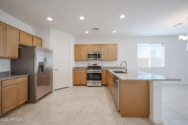 a kitchen with stainless steel appliances granite countertop a refrigerator sink and stove