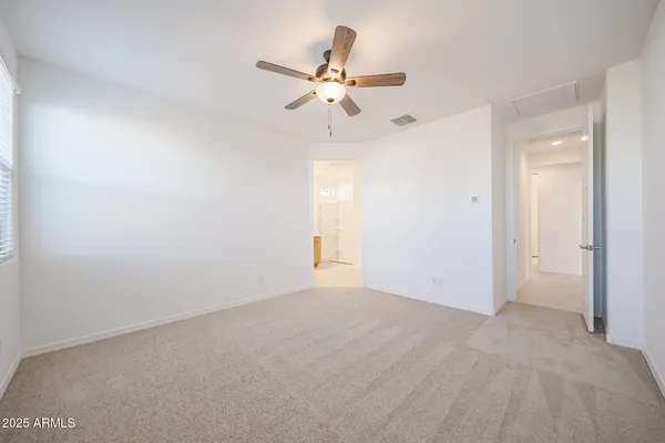 a view of a room with a ceiling fan and window