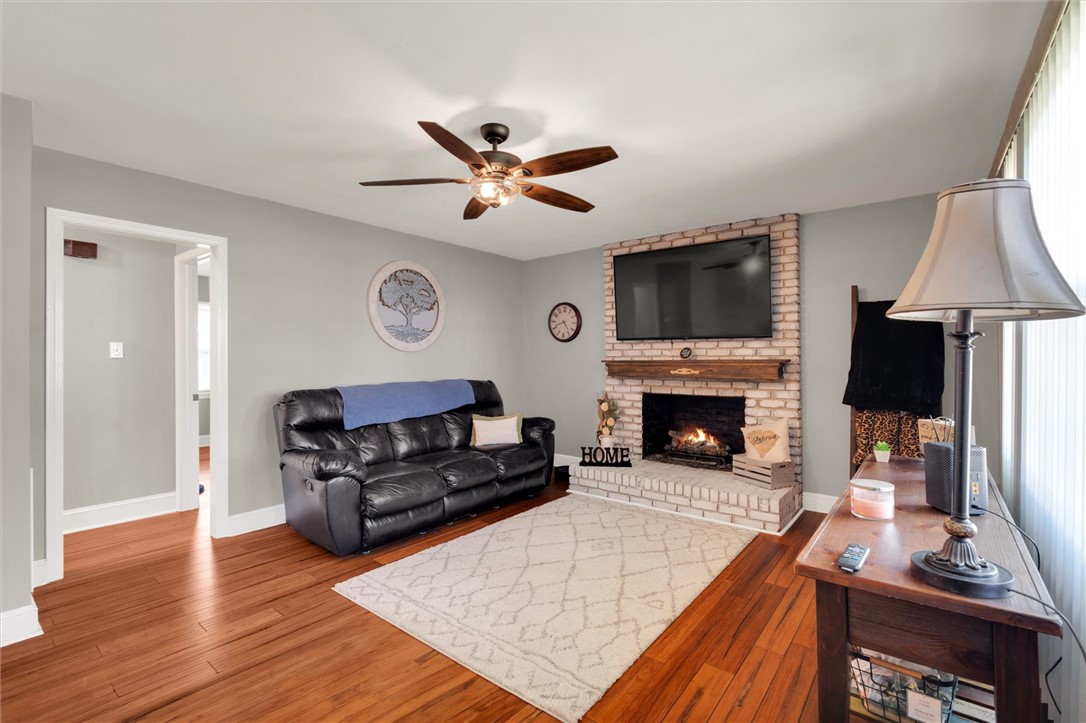 503 Stone Drive Anderson, SC 29625 - Photo 5 of 25 This living room features a fireplace and a ceiling fan, offering both warmth and comfort.