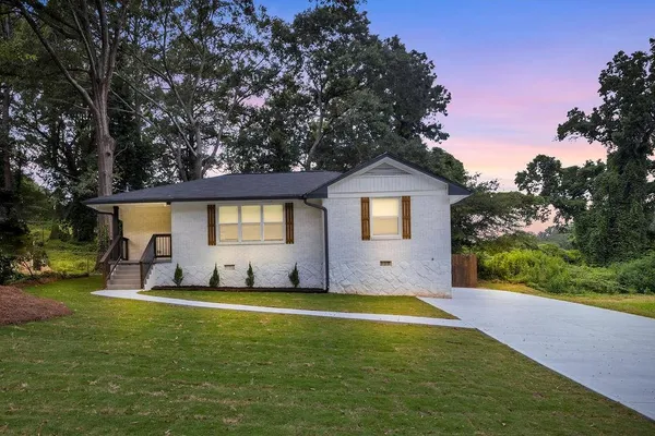 a view of a house with a yard and sitting area