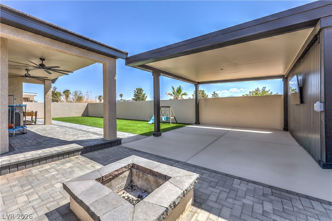 580 Lillian Condie Road Overton, NV 89040 - Photo 33 of 37 An inviting outdoor living space features a built-in fire pit, covered patio, and lush artificial turf.