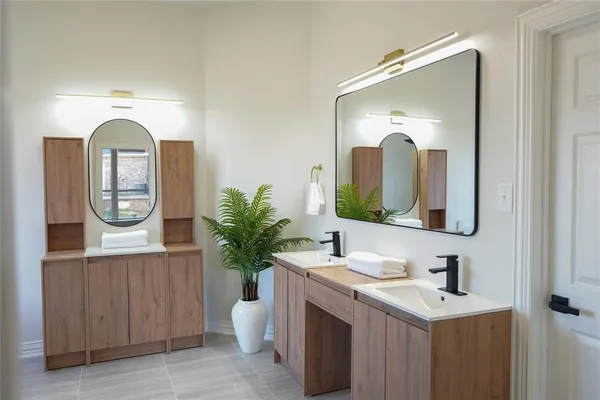 a bathroom with a sink a potted plant and a mirror