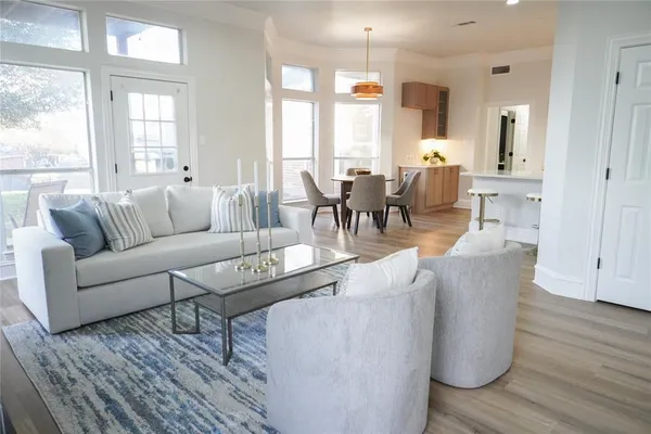a living room with furniture wooden floor and a large window