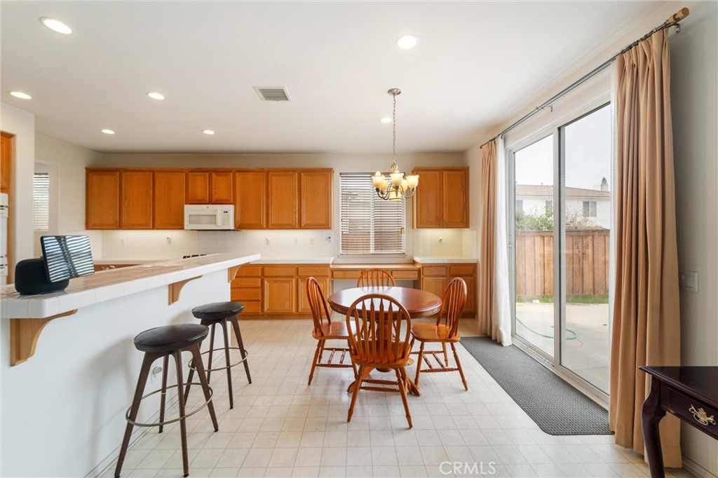 17191 Greentree Drive Riverside, CA 92503 - Photo 11 of 53 a kitchen with stainless steel appliances granite countertop table chairs and wooden floor