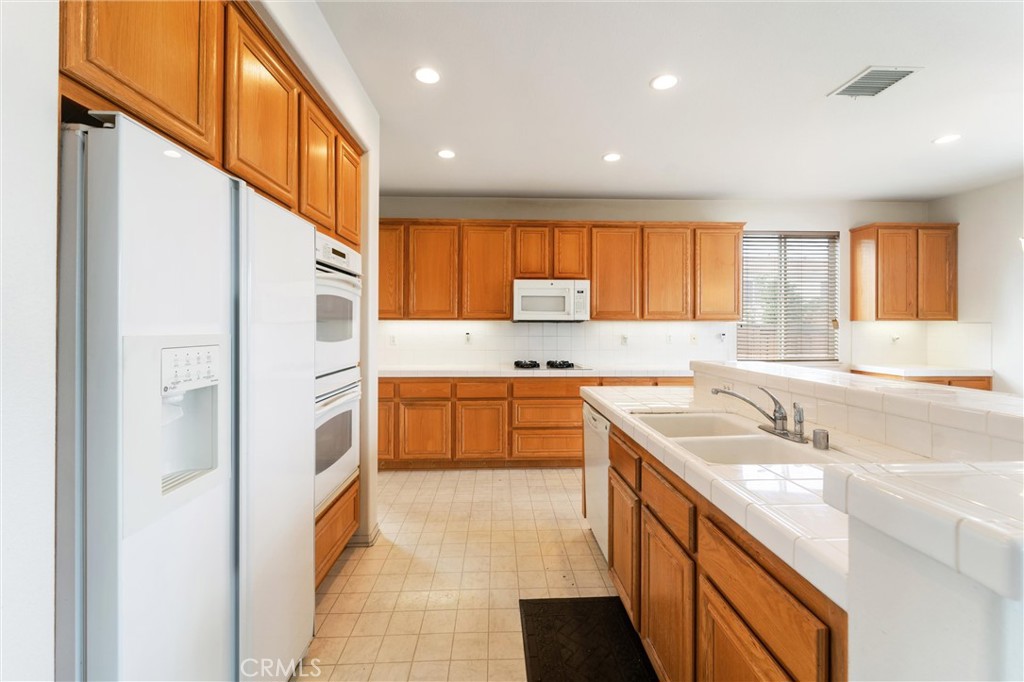17191 Greentree Drive Riverside, CA 92503 - Photo 13 of 53 a kitchen with a sink a counter top space stainless steel appliances cabinets and a large window