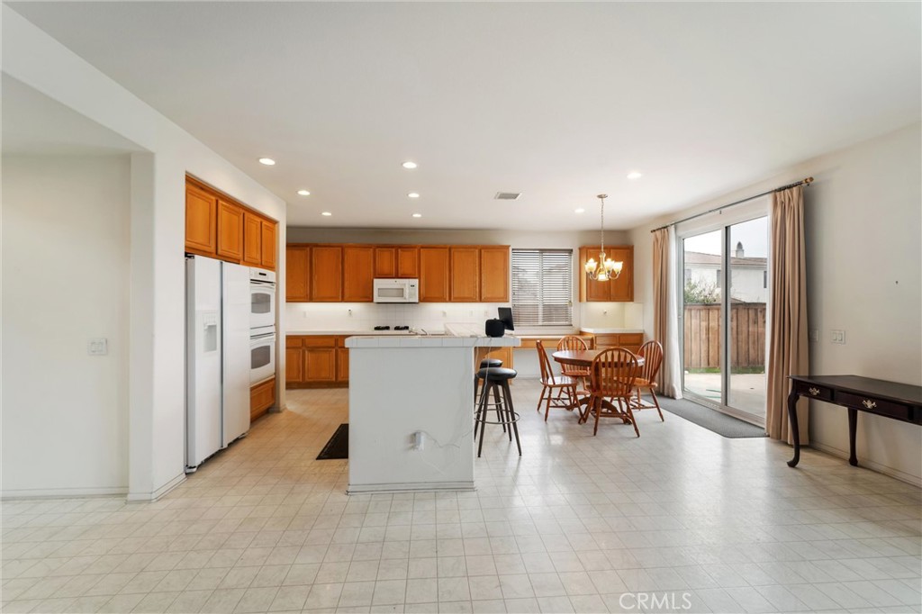 17191 Greentree Drive Riverside, CA 92503 - Photo 14 of 53 a living room with furniture a dining table and a refrigerator