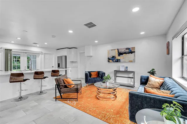 a living room with furniture kitchen view and a table