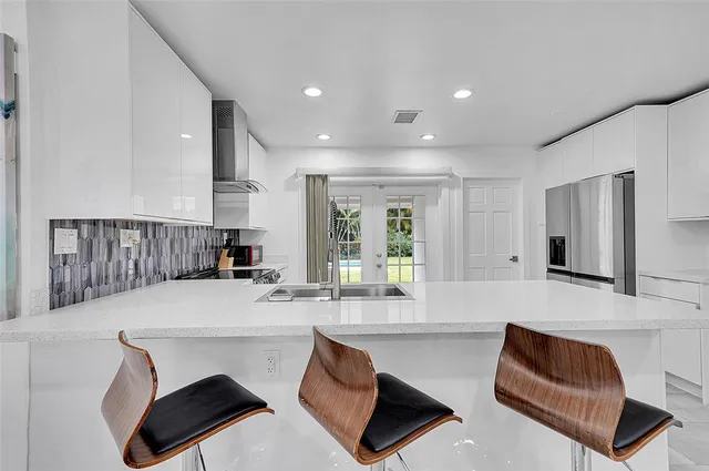 a kitchen with a table chairs sink and cabinets