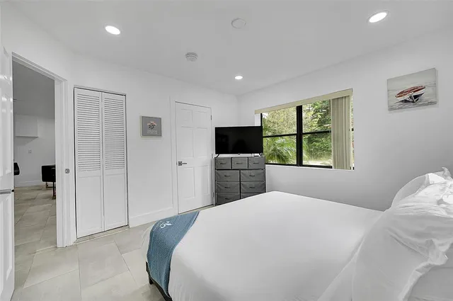 a bedroom with a bed and a flat screen tv