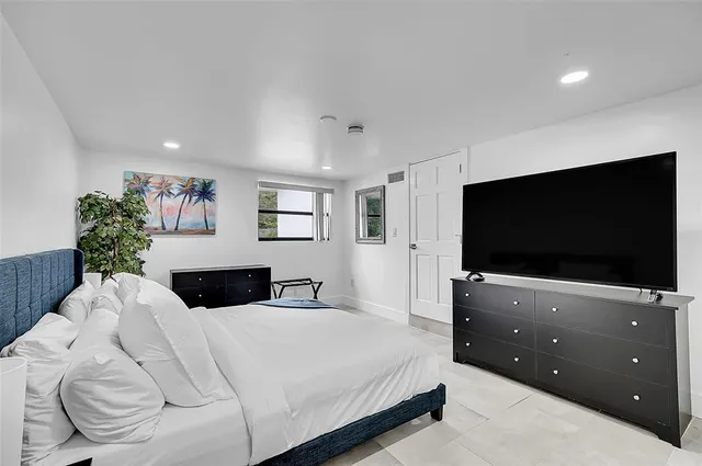 a bedroom with a bed and a potted plant