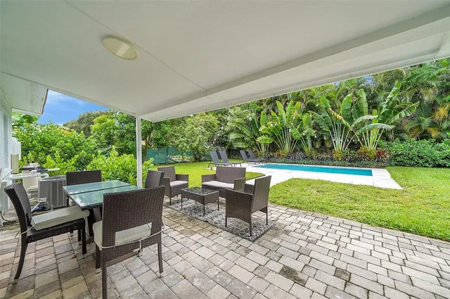 a view of a house with backyard sitting area and garden