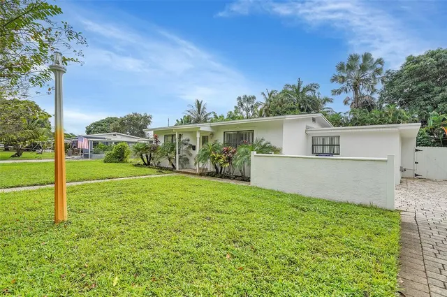 a view of a house with backyard and a tree