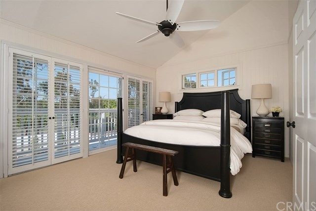 a bed sitting in a spacious bedroom next to a window