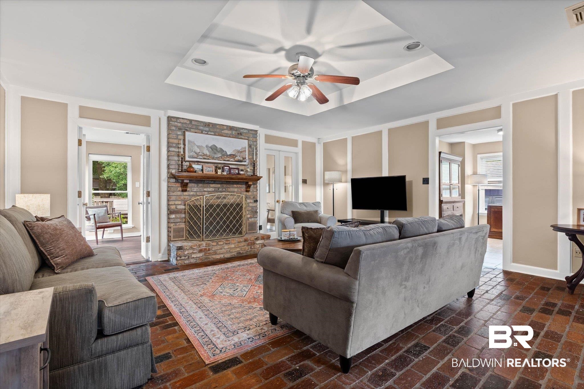 6501 Gas Light Lane South Mobile, AL 36695 - Photo 4 of 23 Living space featuring brick flooring, a stone fireplace with a wood mantel, and a tray ceiling with recessed lighting