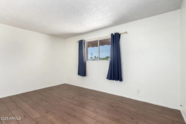 a view of a room with wooden floor and a wall painting