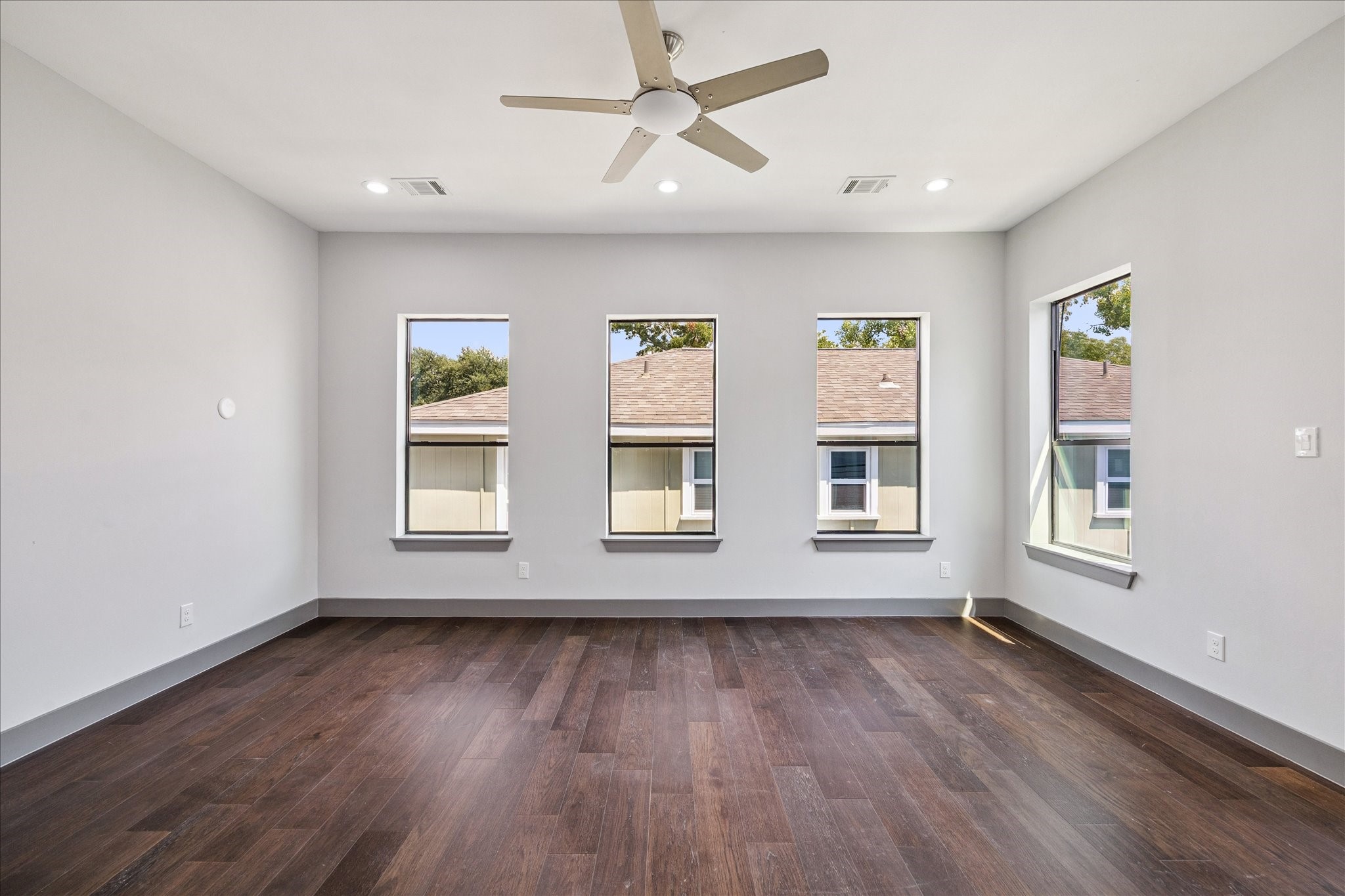 2319 Tuam Street Houston, TX 77004 - Photo 14 of 28 The primary suite features warm wood flooring, recessed lighting, and a ceiling fan for year-round comfort, with a sliding glass door leading to a private balcony and direct access to the en suite bath.