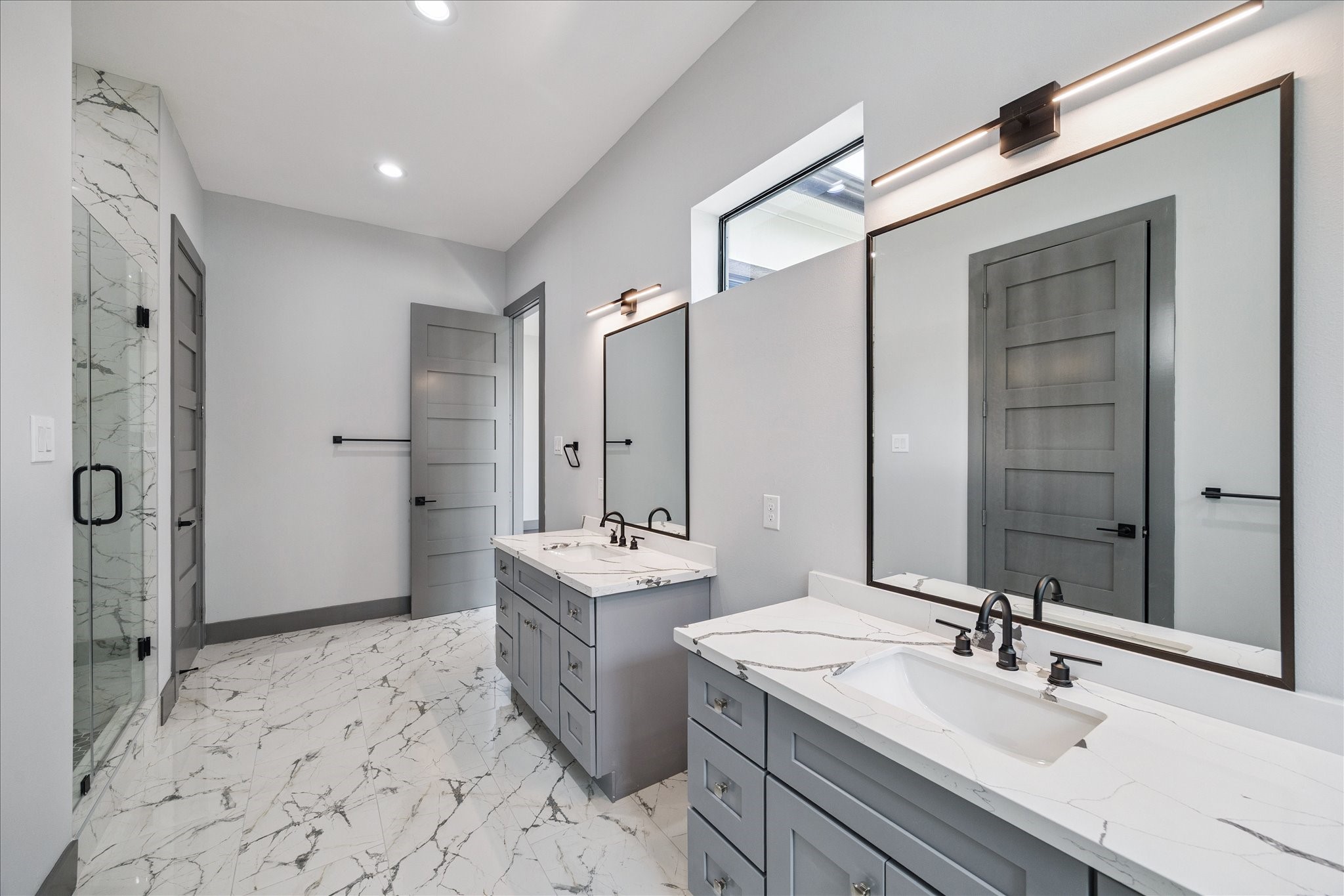 2319 Tuam Street Houston, TX 77004 - Photo 19 of 28 A glass-enclosed shower showcases sleek tile details, complemented by soft lighting that highlights the fresh, contemporary atmosphere.