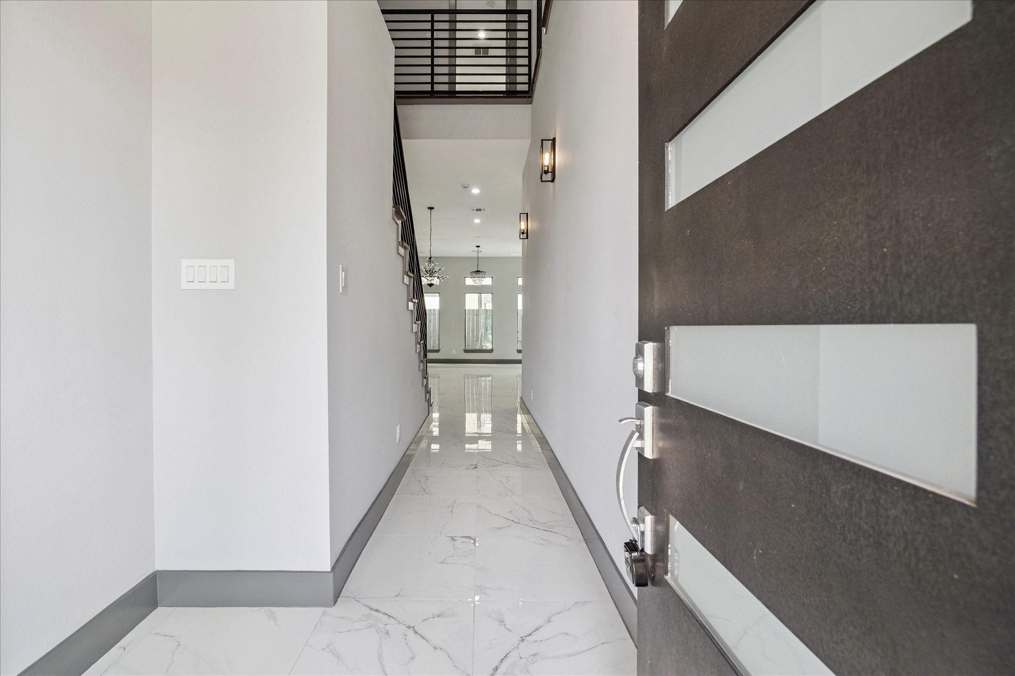 2319 Tuam Street Houston, TX 77004 - Photo 4 of 28 Modern entry sets the tone with porcelain tile floors, crisp lines, and generous natural light. The double-height ceiling and open railing above lead the eye toward the main living areas, establishing a refined sense of arrival.
