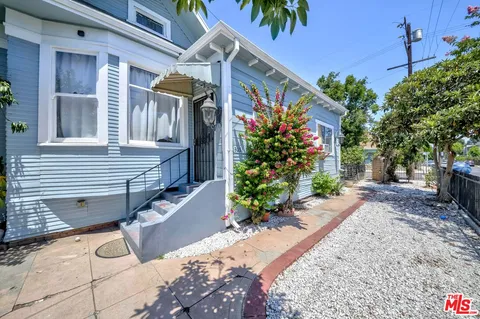 a view of a house with a yard and potted plants