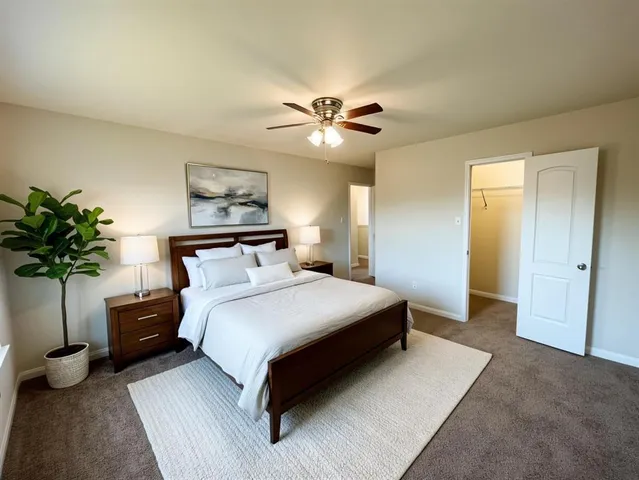 a bedroom with a bed and a potted plant