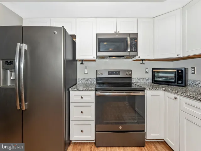 a kitchen with stainless steel appliances a stove microwave and refrigerator