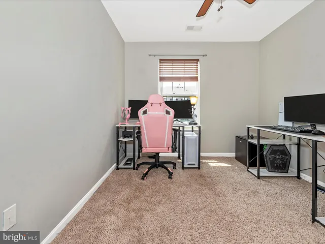 a view of a workspace with furniture and a window