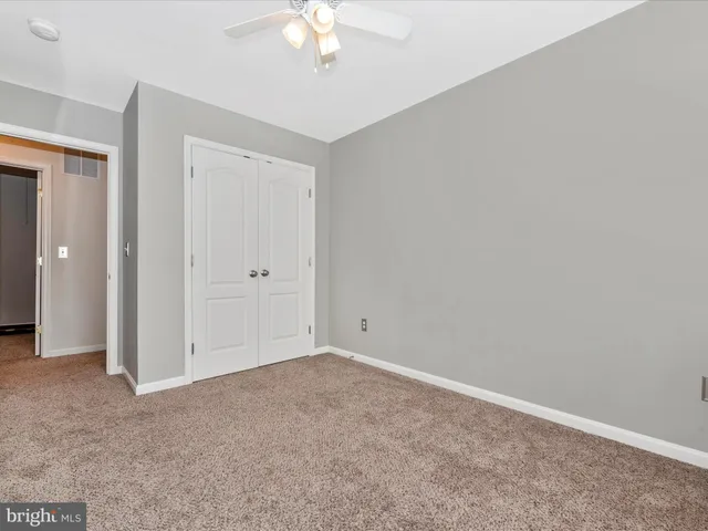 an empty room with a chandelier fan