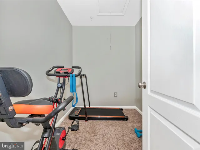 a room with gym equipment and wooden floor