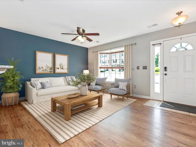 a living room with furniture a chandelier and a window
