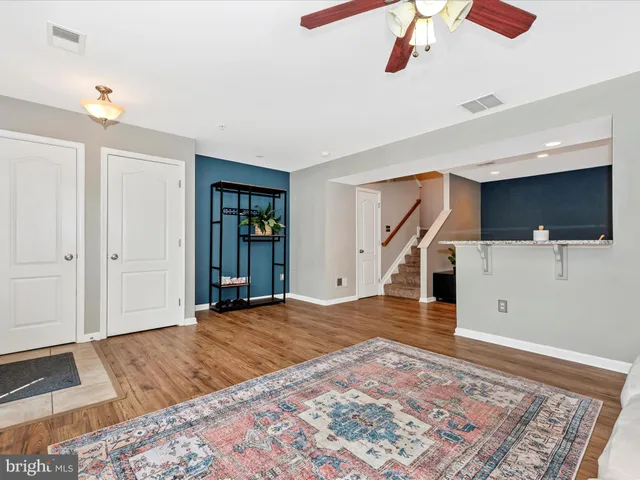 a view of a livingroom with wooden floor and stairs