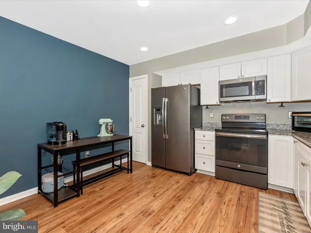 a kitchen with stainless steel appliances a refrigerator and a stove top oven