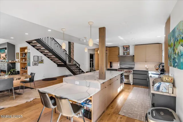 a kitchen with stainless steel appliances granite countertop a sink a stove and a wooden floors