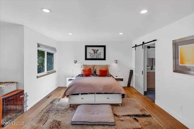 a bedroom with a bed a chair and painting on the wall