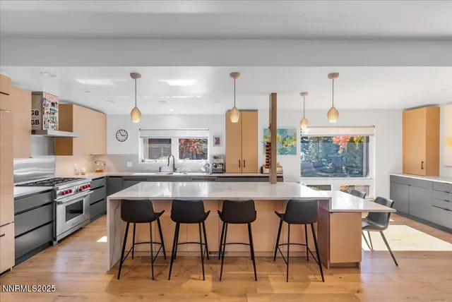 a kitchen with stainless steel appliances kitchen island granite countertop a table chairs sink and cabinets