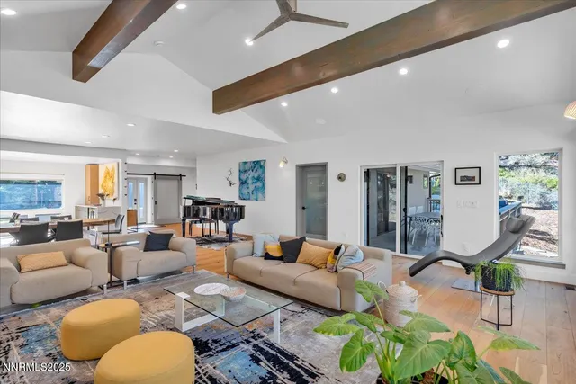 a living room with furniture kitchen view and a wooden floor