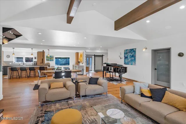 a living room with furniture kitchen view and a large window