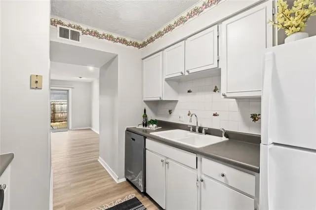 a kitchen with a sink cabinets and wooden floor