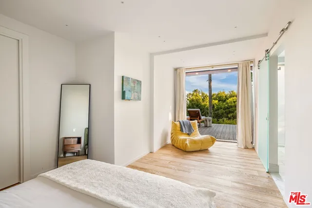 a bedroom with a bed and a large window