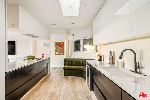 a kitchen with kitchen island granite countertop a sink and wooden cabinets