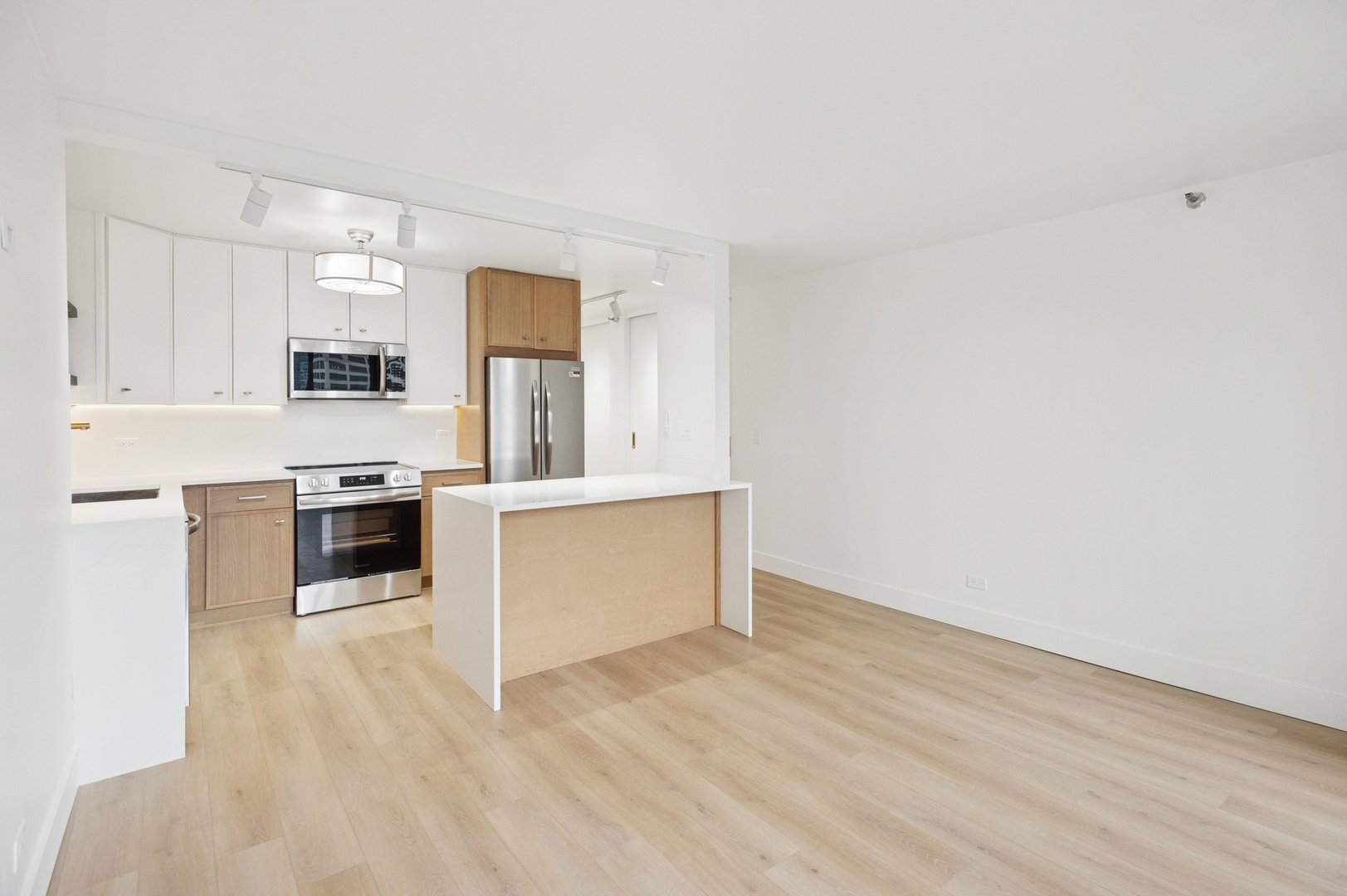 200 North Dearborn Street, Unit 4301 Chicago, IL 60601 - Photo 4 of 21 a large kitchen with granite countertop a stove a sink and white cabinets with wooden floor